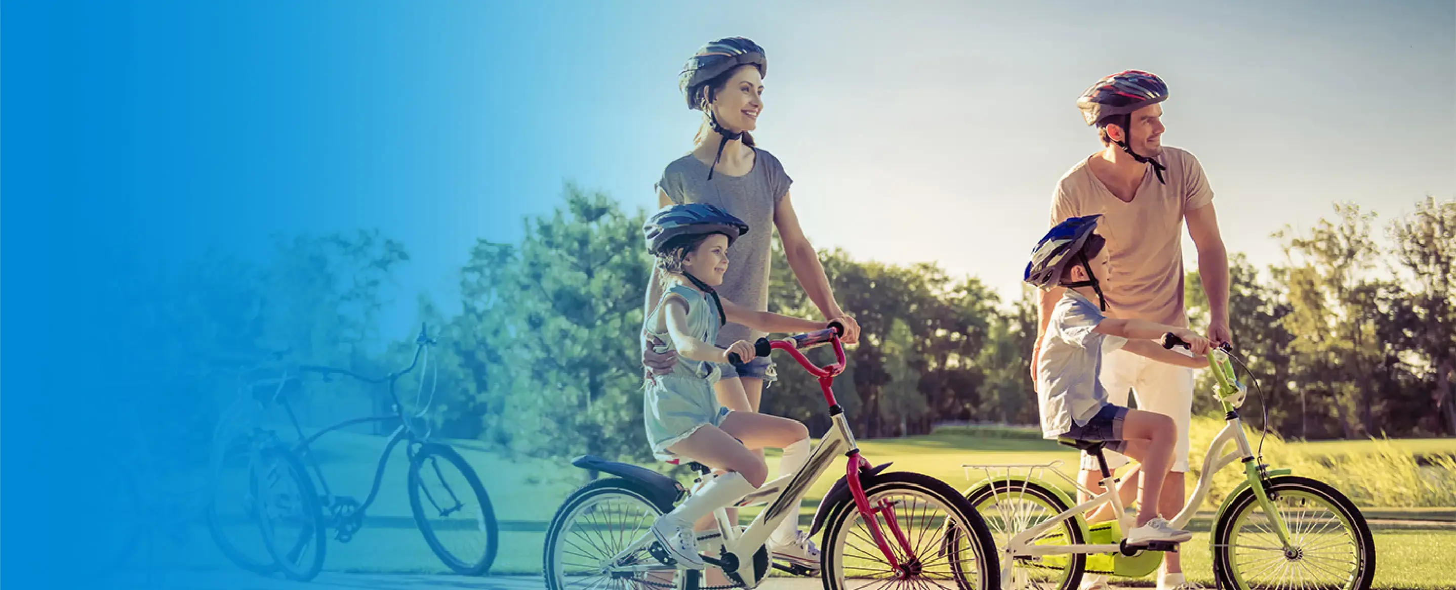 Familia con dos niños paseando en bicicleta al aire libre con cascos de seguridad
