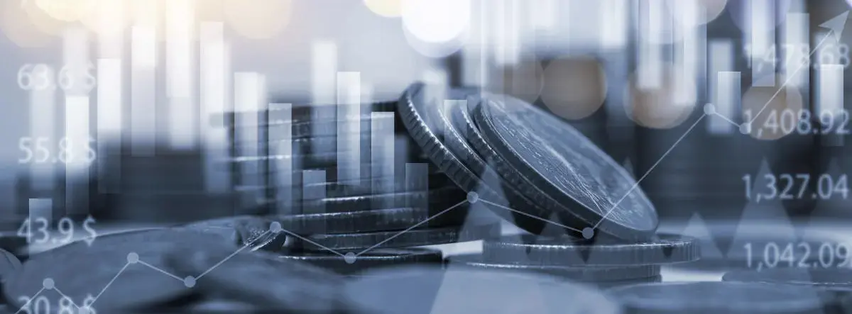 Montones de monedas apiladas con gráficos financieros y barras de crecimiento superpuestos, representando análisis e inversión económica.