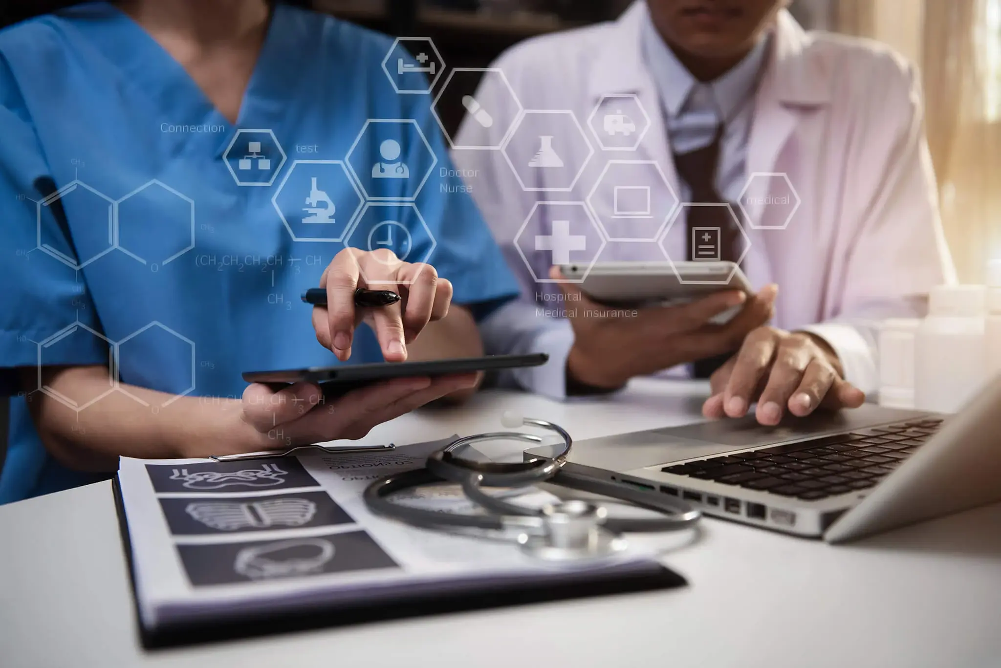 Médicos revisando información en una tableta y computadora portátil con gráficos médicos y símbolos de salud superpuestos.