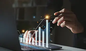 Mano señalando una gráfica digital de crecimiento en la pantalla de una laptop.