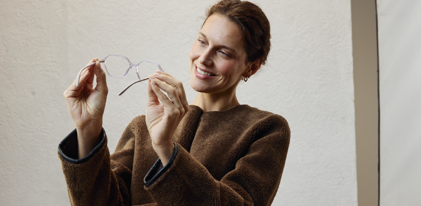 Grupo de profesionales en una oficina asistiendo a una presentación frente a una pizarra blanca.